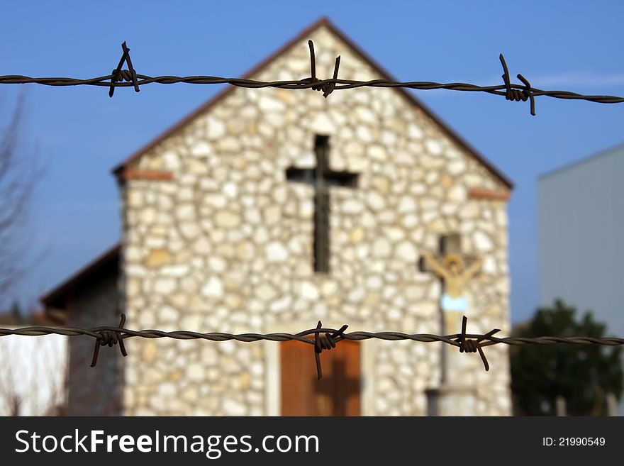 Chapel behind the barbed wire. Focus in the foreground.