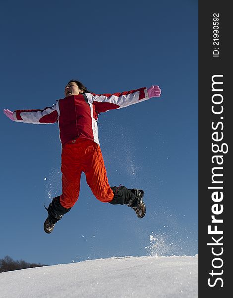 Young woman jumping in snow
