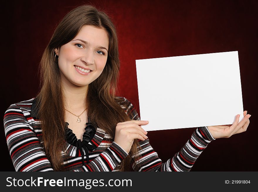 Young woman holding empty white board, on a  red background