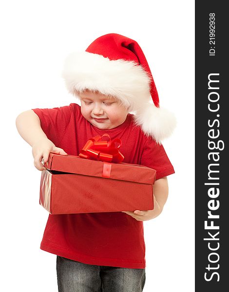 Adorable boy in Santa hat opening christmas gift in red box isolated on white