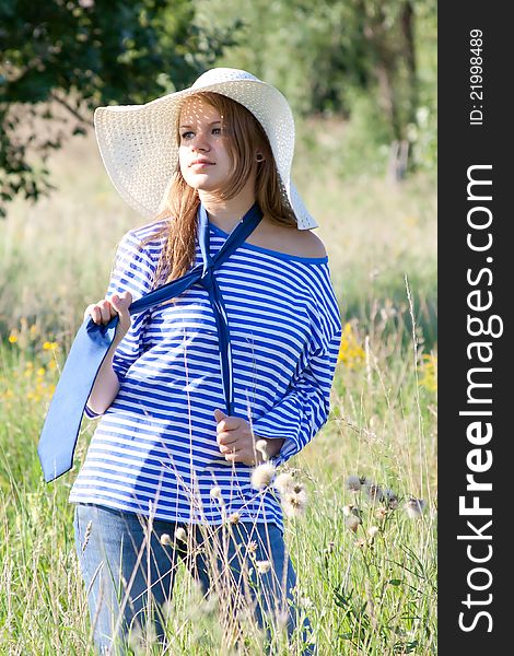 Beautiful girl in the shirt on the grass outdoors shooting