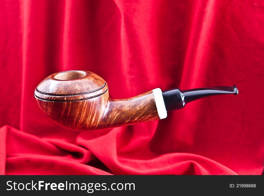 A new pipe for tobacco smoking was photographed against a red background