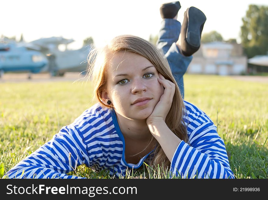 Beautiful girl in the shirt on the grass outdoors shooting