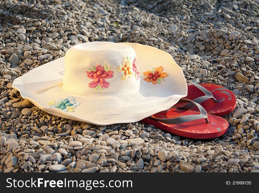 Hat and flip-flops on the stones