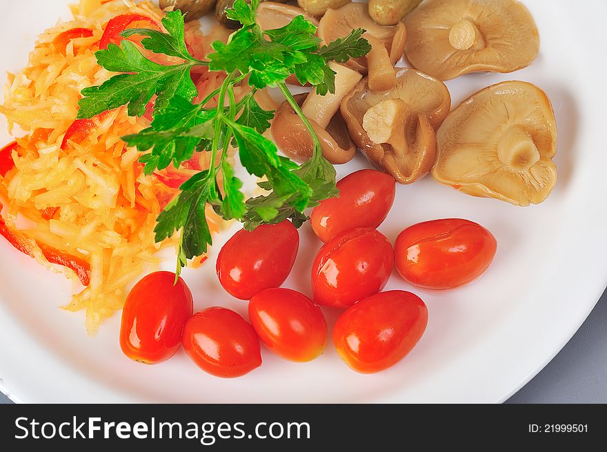 Marinated cabbege tomato and mushrooms on plate. Marinated cabbege tomato and mushrooms on plate