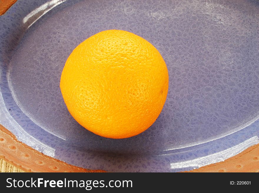 Ripe orange in a blue ceramic dish. Ripe orange in a blue ceramic dish