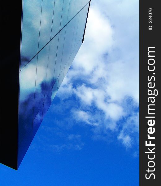 Black wall reflecting a blue sky with clouds. Black wall reflecting a blue sky with clouds