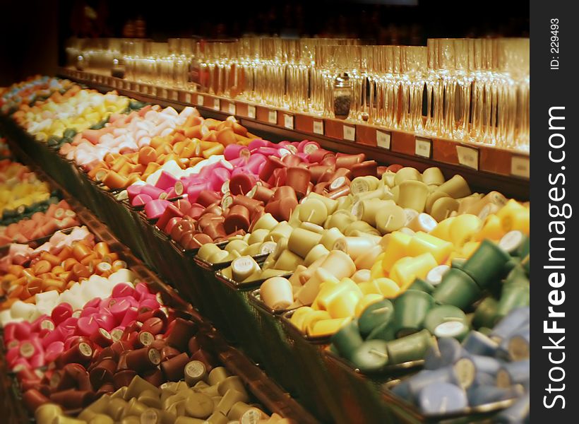 Objects. Bins of brightly colored tea candles and glass votive holders. Objects. Bins of brightly colored tea candles and glass votive holders.