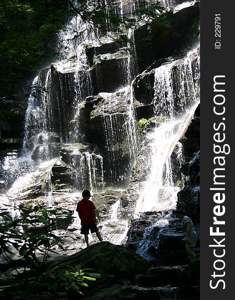 Boy in silhouette in front of a waterfall. Boy in silhouette in front of a waterfall