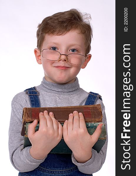 The boy in glasses and with books smiles on a white background. The boy in glasses and with books smiles on a white background