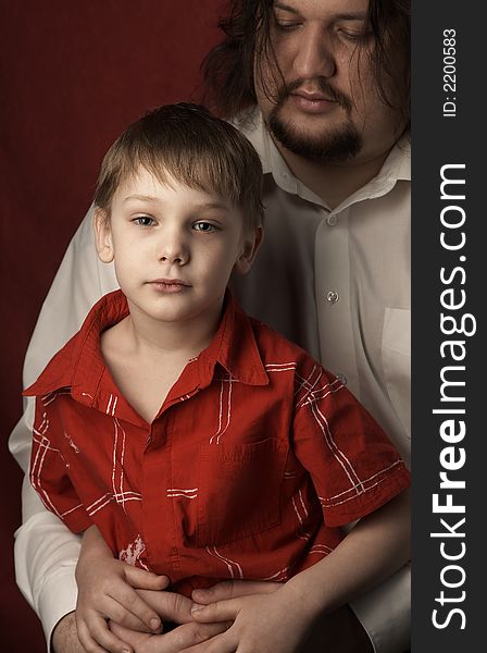 Father and son in red shirt on red background