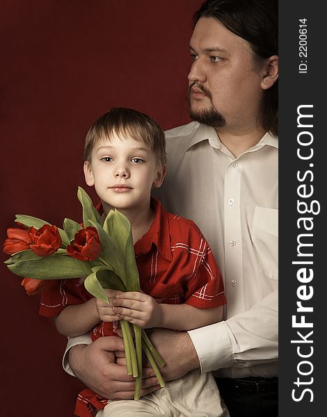 father and son keeping bouquet of red tulips. father and son keeping bouquet of red tulips