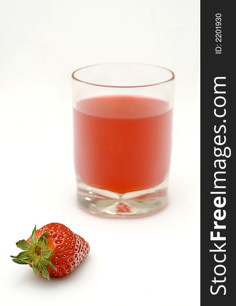 A fresh strawberry and a glass of strawberry juice. A fresh strawberry and a glass of strawberry juice
