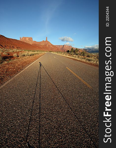 A road in the desert near moab in castle valley utah with tripod shadow. A road in the desert near moab in castle valley utah with tripod shadow