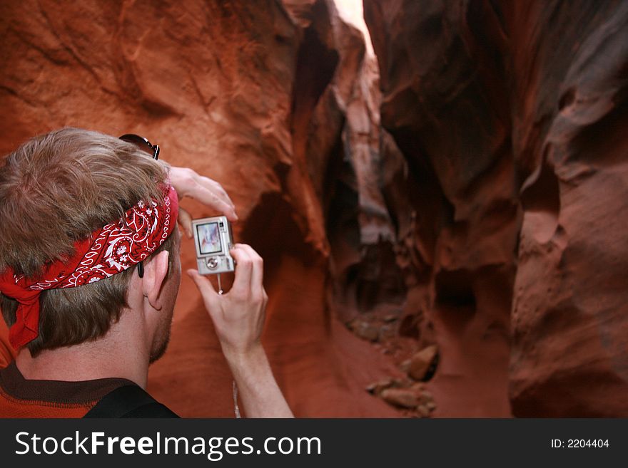 taking a photo and slot canyon hiking in dryfork canyon in escalante utah. taking a photo and slot canyon hiking in dryfork canyon in escalante utah