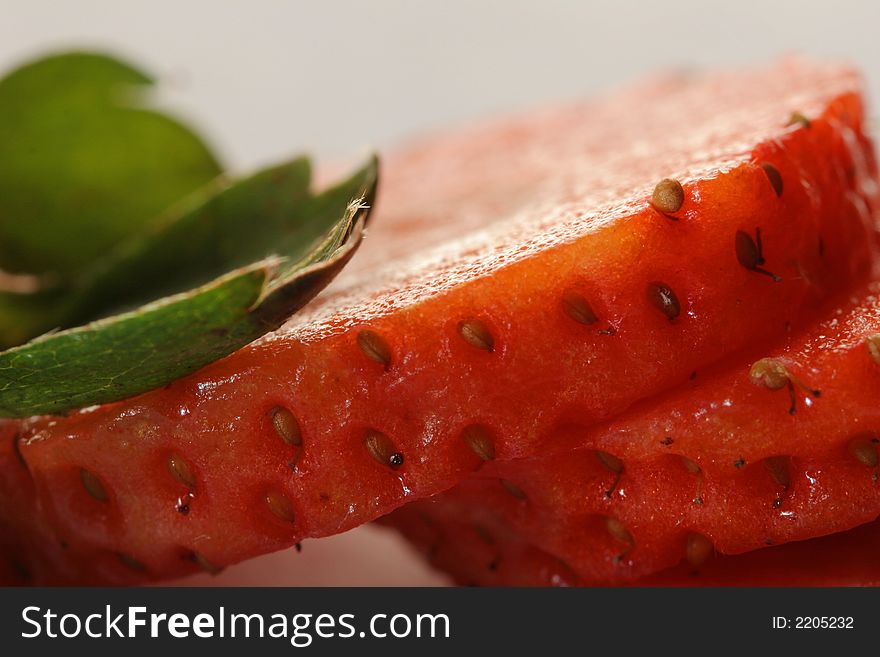 Segments of ripe cut strawberry with leaves. Segments of ripe cut strawberry with leaves