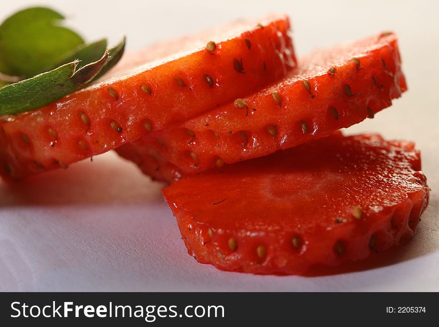 Segments of ripe cut strawberry with leaves. Segments of ripe cut strawberry with leaves