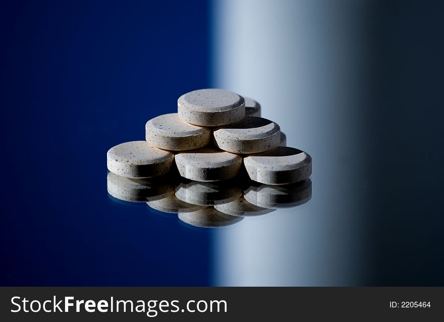 Pill pyramid and reflection - blue and white background