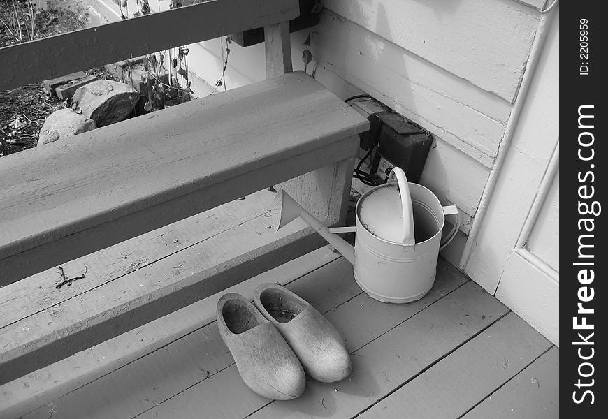 Wooden shoes and watering can in gray
