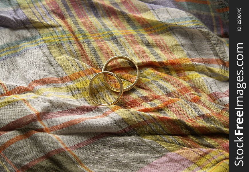 Two wedding rings on a colourful cloth background. Two wedding rings on a colourful cloth background