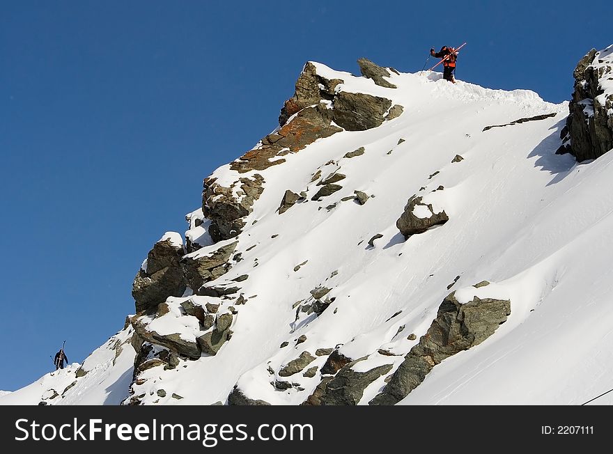 Breathtaking Snowy mountains landscape with blue skies and skiers climbing. Breathtaking Snowy mountains landscape with blue skies and skiers climbing