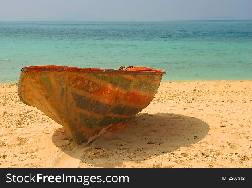 The old thrown boat on a beach in Phuket