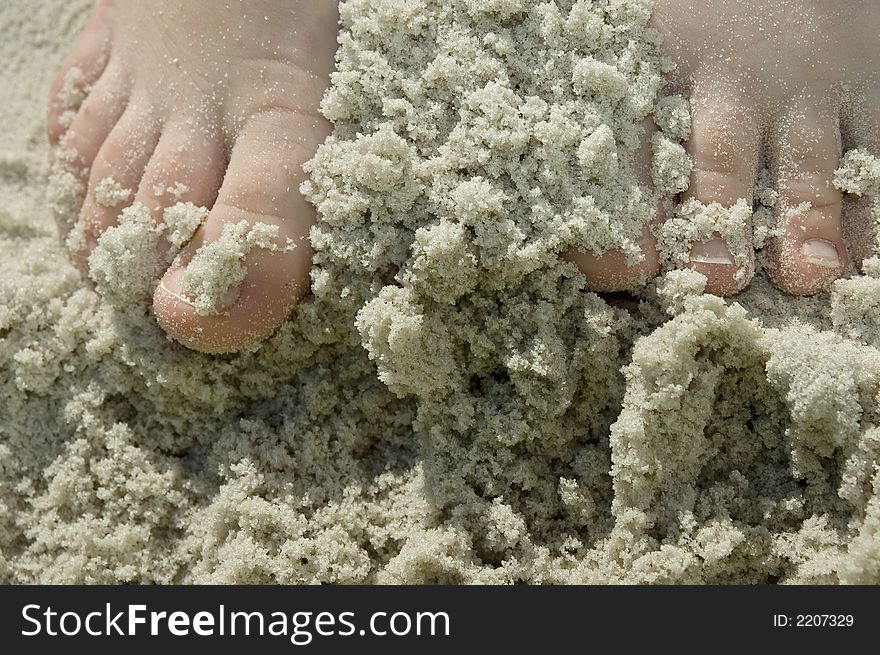 A child's feet in sandy beach. A child's feet in sandy beach