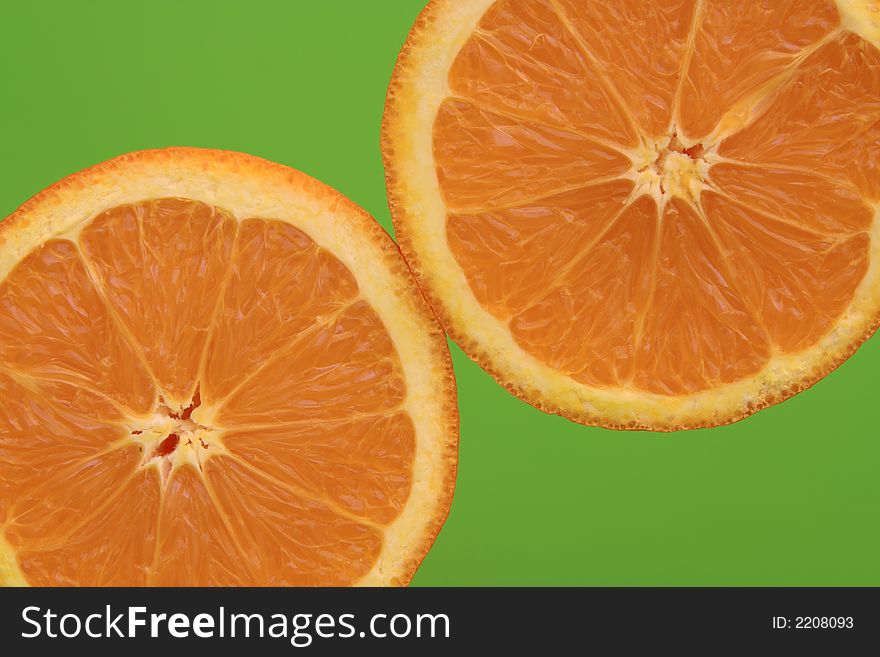 Two oranges with green background