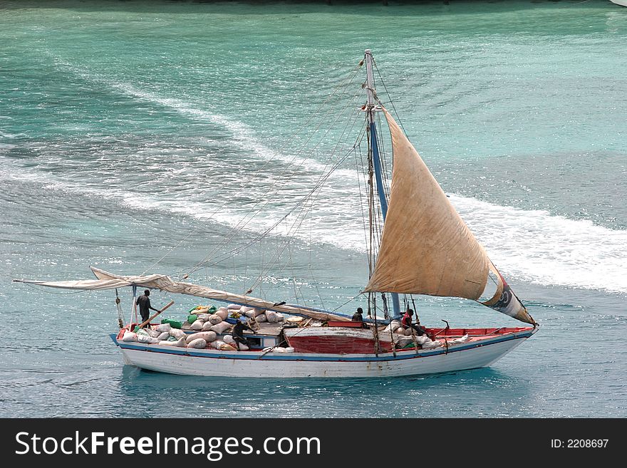 A sailing boat in the bay at Nassau with workers aboard. A sailing boat in the bay at Nassau with workers aboard