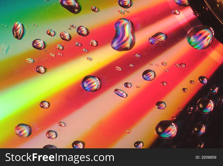 Rays of colorful light on a disc with water droplets. Rays of colorful light on a disc with water droplets