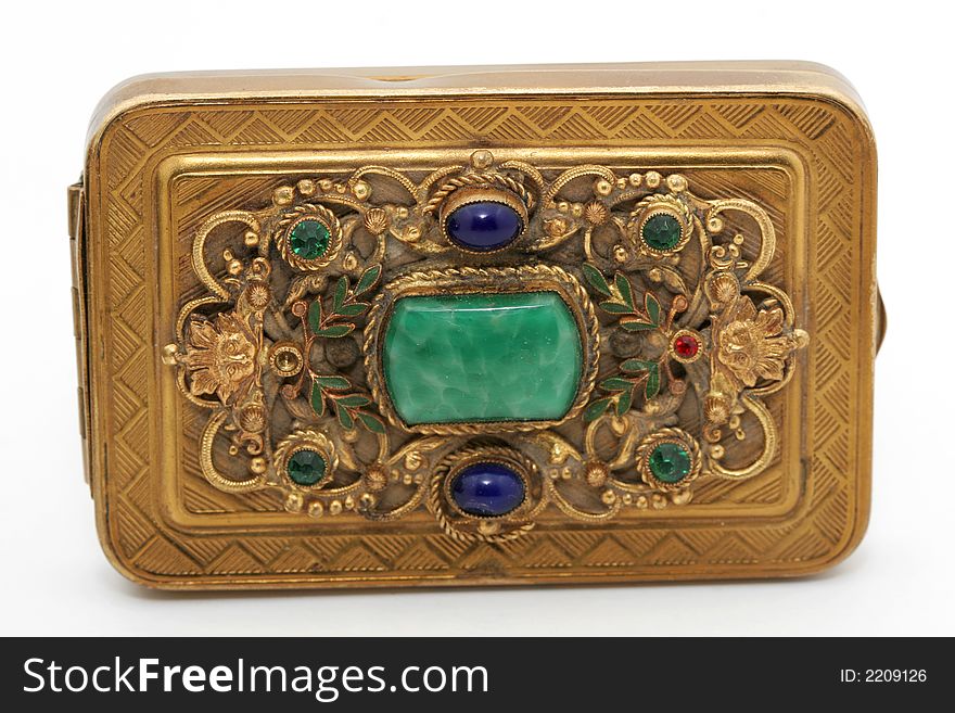 A close up of a gold jewel box with inlaid jewels, isolated on white