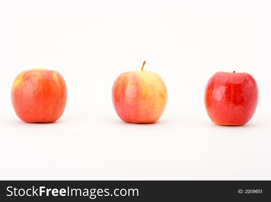Three Pink Lady apples in a horizontal line