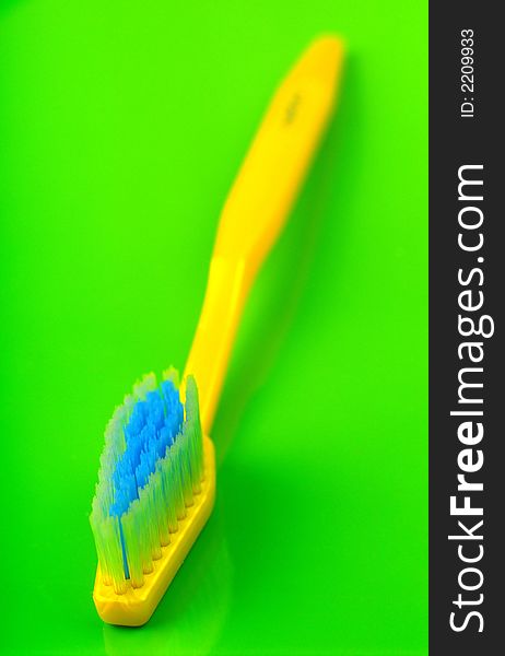Pure, new, yellow color tooth-brush on green background. Pure, new, yellow color tooth-brush on green background