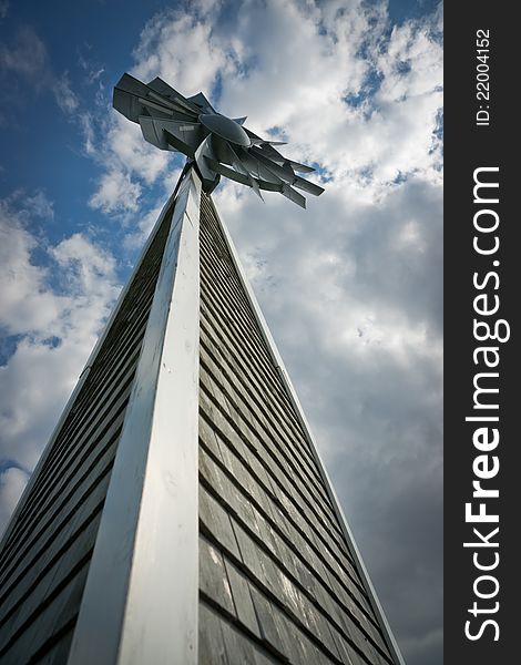 Unusual perspective of a tall, wooden windmill under a cloudy blue sky. Unusual perspective of a tall, wooden windmill under a cloudy blue sky