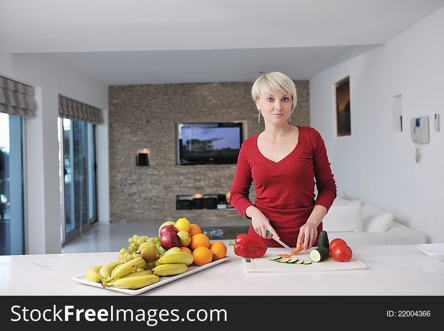 Happy blonde  woman prepare food in  the kitchen