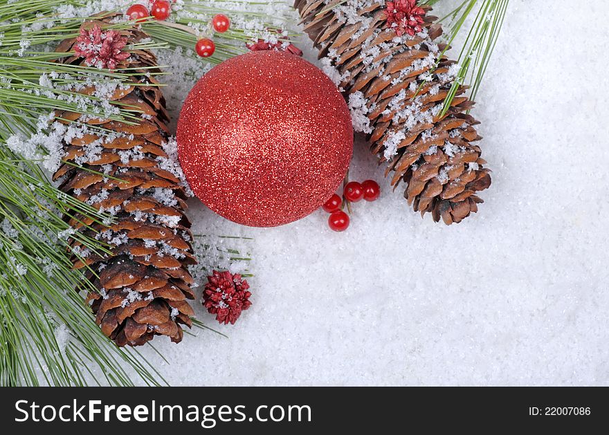 Red ornament with pine cones on a snowy white background. Red ornament with pine cones on a snowy white background