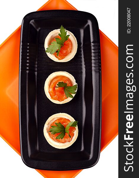 Canape with smoked salmon fish on black plate