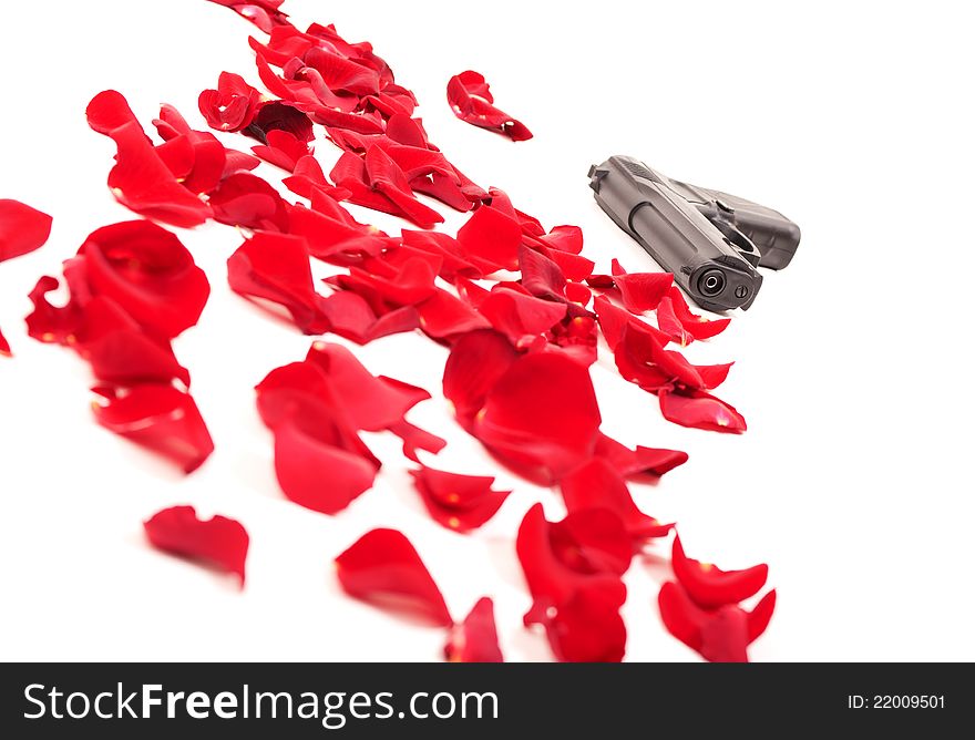Gun between the rose petals isolated on white
