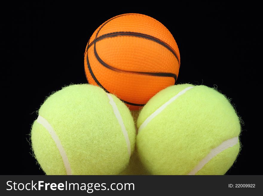 Basketball on tenis balls on black background