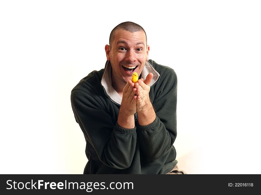 A handsome man on a white background holds a chick - the symbol of Easter and new life. A handsome man on a white background holds a chick - the symbol of Easter and new life.