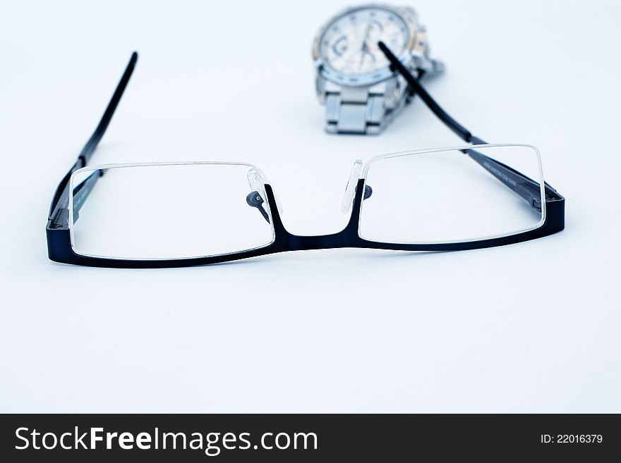 Close-up of glasses and wrist watch isolated on a white background. Close-up of glasses and wrist watch isolated on a white background.