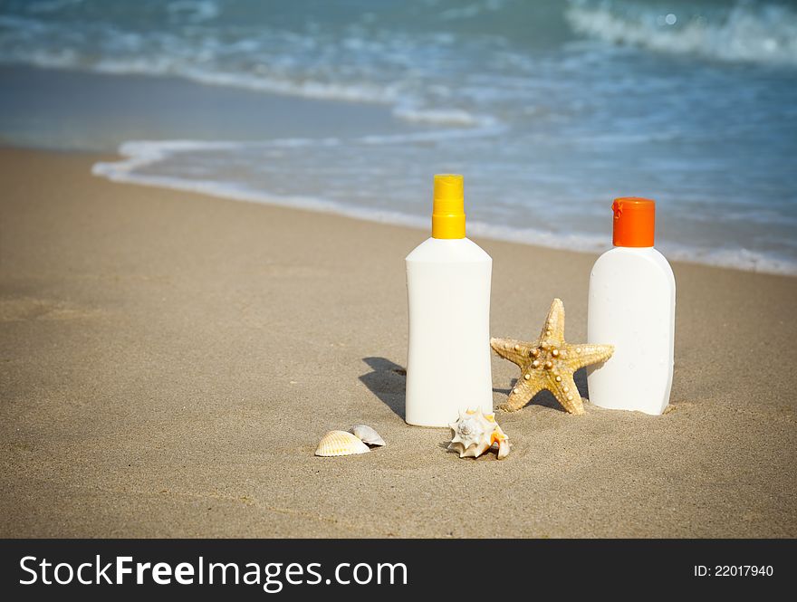 Suntan Lotion Flacons on the Beach with copy space / seasonal