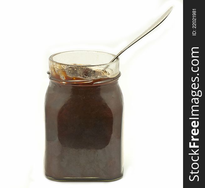 Jar of plum jam and a spoon. Jar of plum jam and a spoon