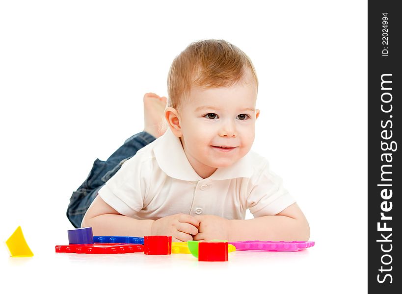 Child is playing with toys while lying on floor, isolated over white. Child is playing with toys while lying on floor, isolated over white