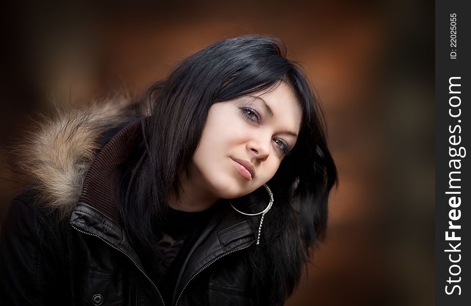 Young woman in a leather jacket on blurred background. Young woman in a leather jacket on blurred background