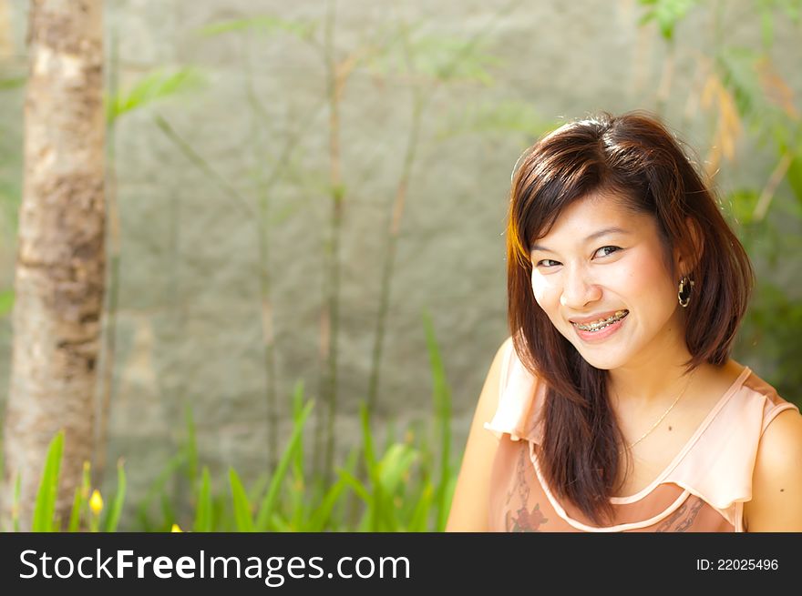 Pretty young woman smiling with braces and blur background. Pretty young woman smiling with braces and blur background