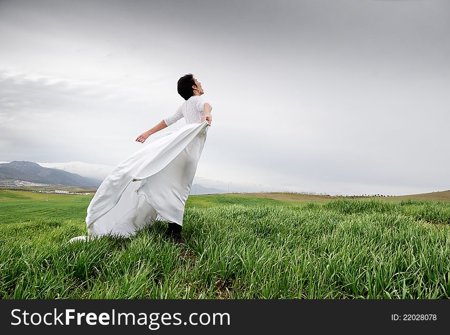 Woman wearing a wedding dress screaming in the field in Granada, Andalusia, Spain