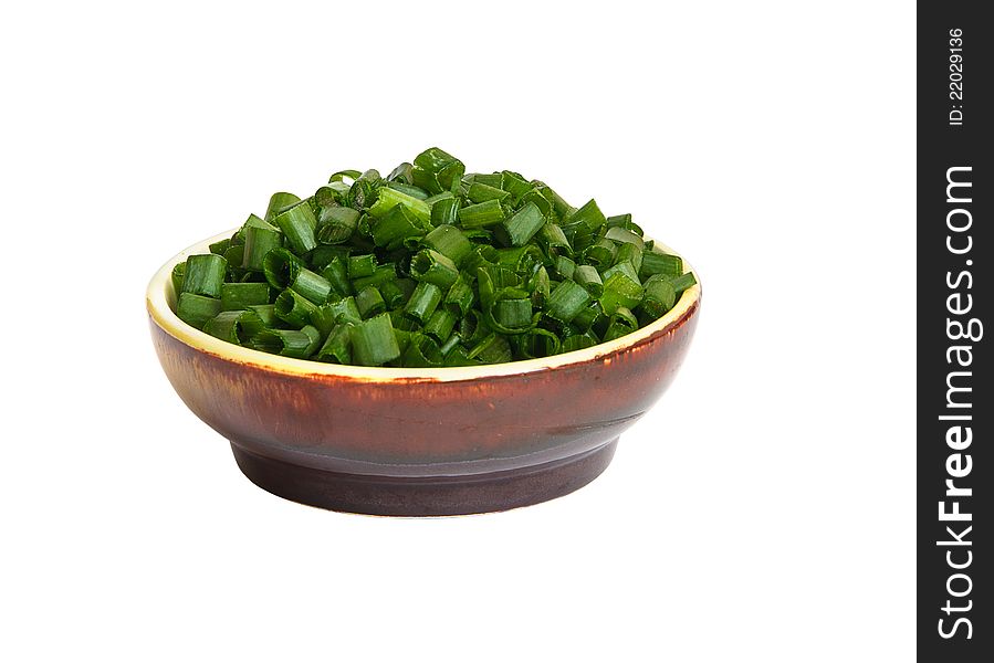 Appetizing finely chopped green leek in round brown drinking bowl for food decoration isolated on white background. Appetizing finely chopped green leek in round brown drinking bowl for food decoration isolated on white background