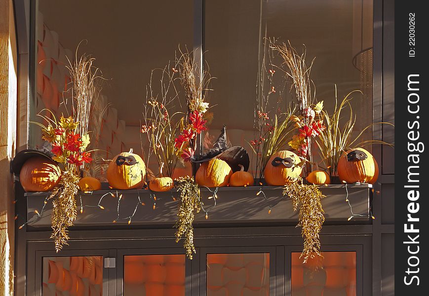 Decorated pumpkins on window ledge surrounded by orange lighting. Decorated pumpkins on window ledge surrounded by orange lighting