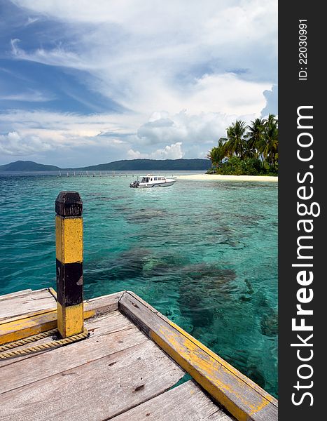 A boat docks in a tropical island. This landscape picture taken in Raja Ampat Island, papua, Indonesia. One of the most beautiful place on earth for diving and sightseeing. A boat docks in a tropical island. This landscape picture taken in Raja Ampat Island, papua, Indonesia. One of the most beautiful place on earth for diving and sightseeing.